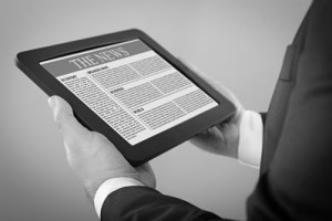 Man reading the news off of a tablet.